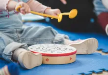 Toddler playing hand drum